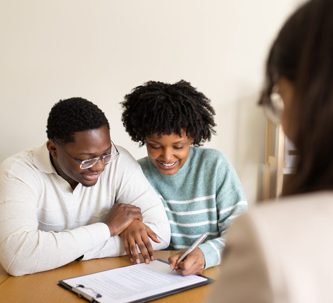 A couple reviewing loan paperwork at a table with their loan officer